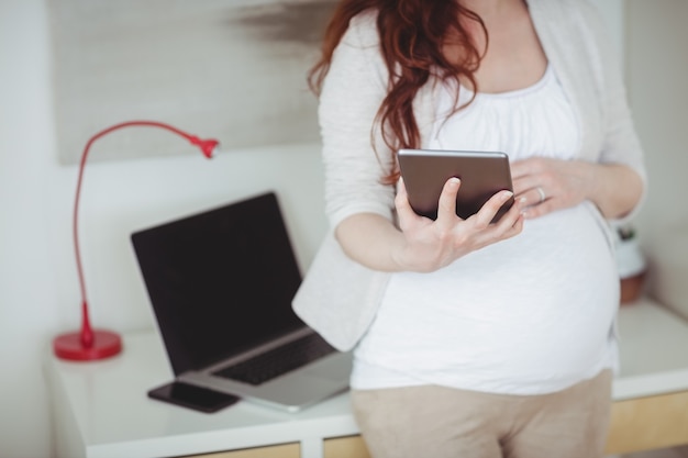 Средняя часть беременной женщины с помощью цифрового планшета в кабинете