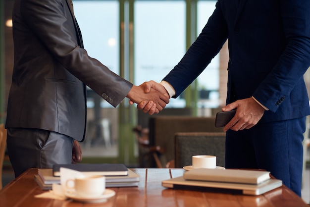 Free photo mid-section of two unrecognizable businessmen shaking hands to finalize the deal