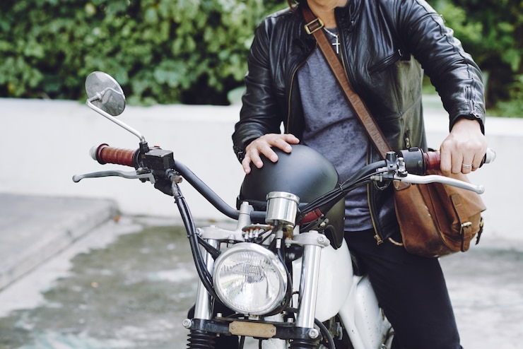 無料Photo バイクに座っているヘルメットと革のジャケットで認識できない男の中間セクション