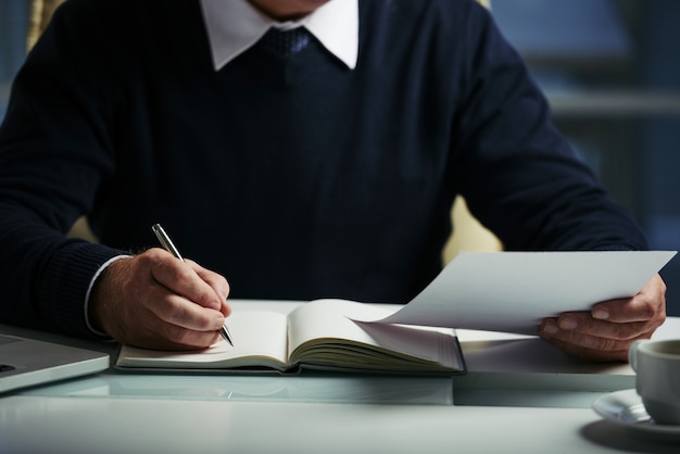 Free photo mid section of unrecognizable man making notes