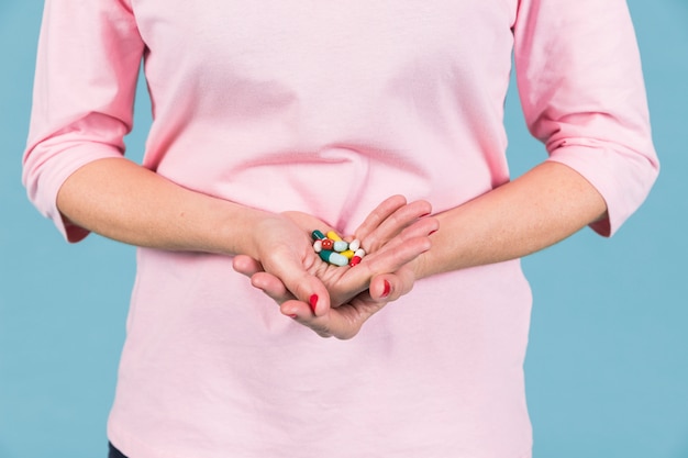 Free photo mid-section of a woman holding variety of capsule's in hand