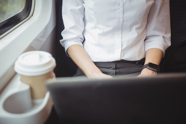 Mid-section of woman using laptop