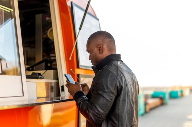 Mid shot black male ordering at food truck