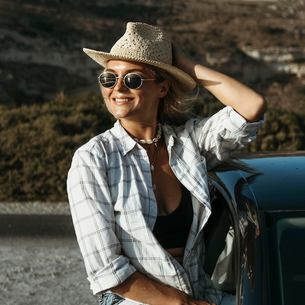 Mid shot blonde woman standing out of car window