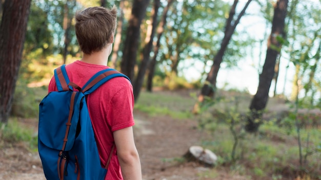 Mid shot boy with backpack in forest