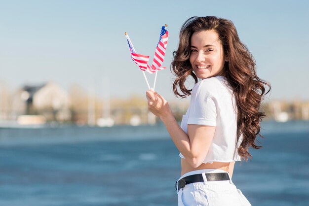 Mid shot brunette woman holding two usa flags