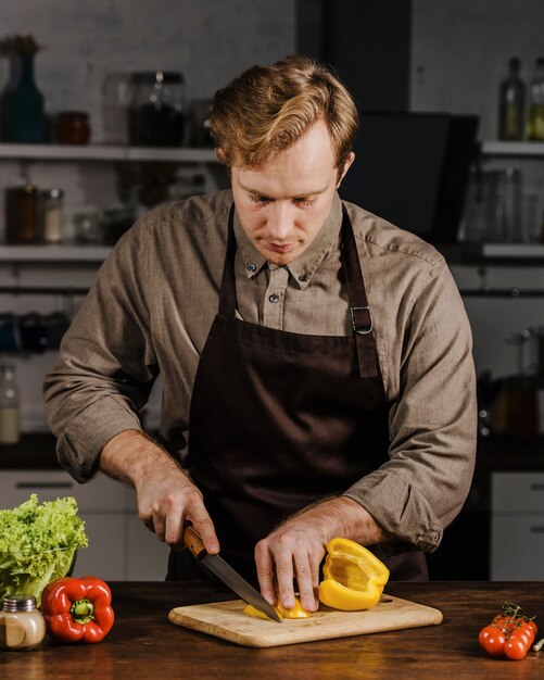 Mid shot chef slicing bell peppers