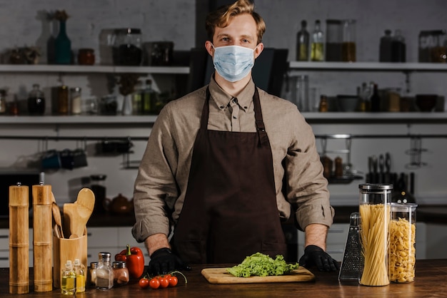 Mid shot chef with mask and salad