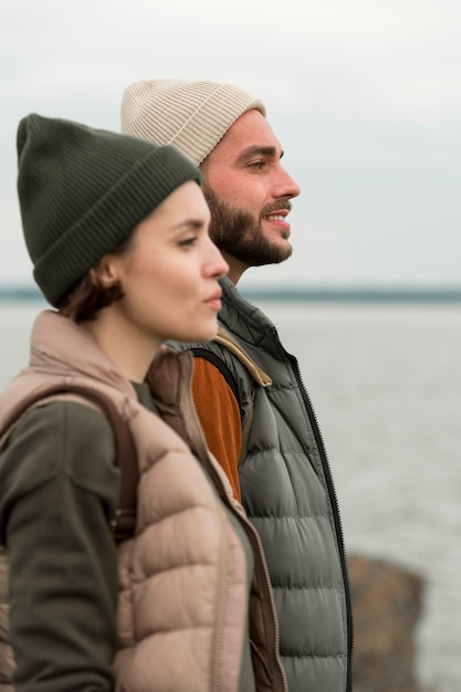 Free photo mid shot couple looking towards water