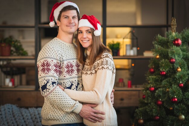 Mid shot couple wearing sweaters embracing eachother