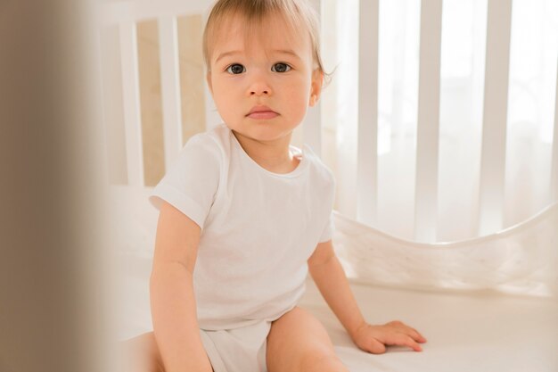 Mid shot cute baby sitting in crib