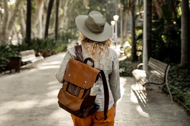 Mid shot female with hat walking in nature