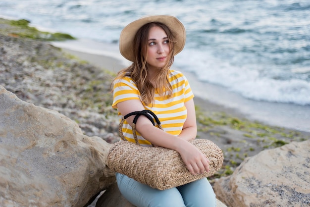 Foto gratuita ragazza a metà colpo con cappello in spiaggia