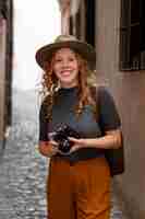 Free photo mid shot girl with hat and camera