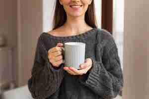 Free photo mid shot happy woman holding mug