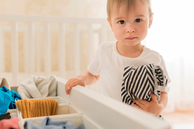 ミッドショットの子供が引き出しから服を着て