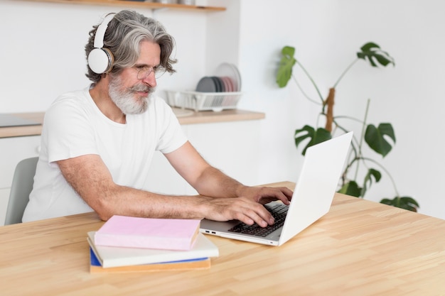 Foto gratuita metà uomo del colpo allo scrittorio facendo uso del computer portatile