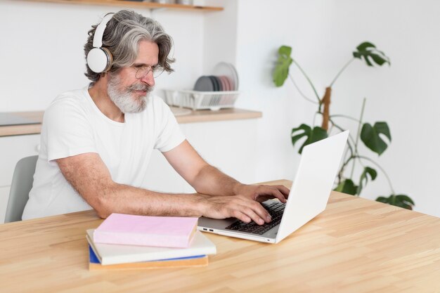 Mid shot man at desk using laptop