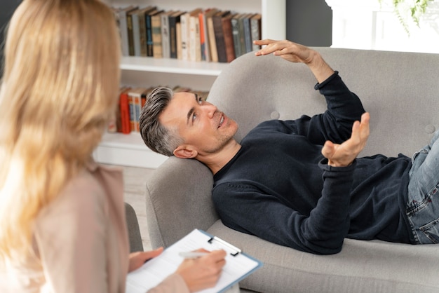 Mid shot man laying on couch in therapy cabinet