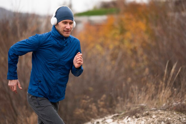 Mid shot man running through nature