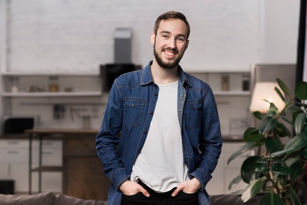 Mid shot man standing up and smiling in living room