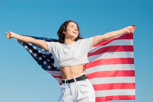 Mid shot smiling woman holding big usa flag