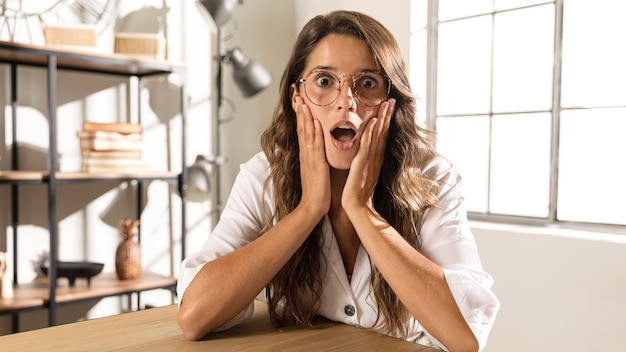 Free photo mid shot surprised woman at table