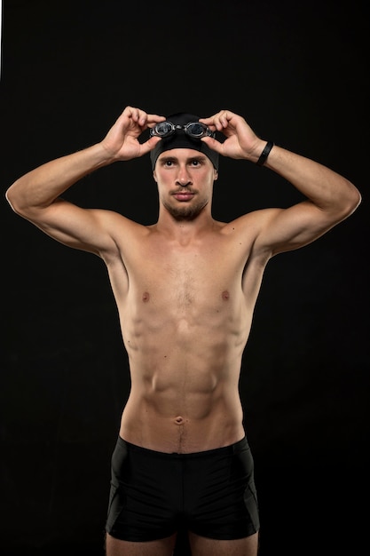 Free photo mid shot swimmer fixing goggles