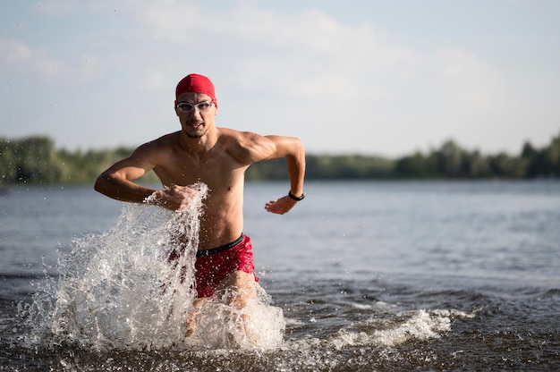 Free photo mid shot swimmer running in lake