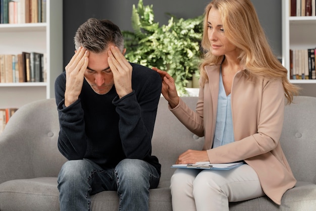 Mid shot woman counselor comforting therapist