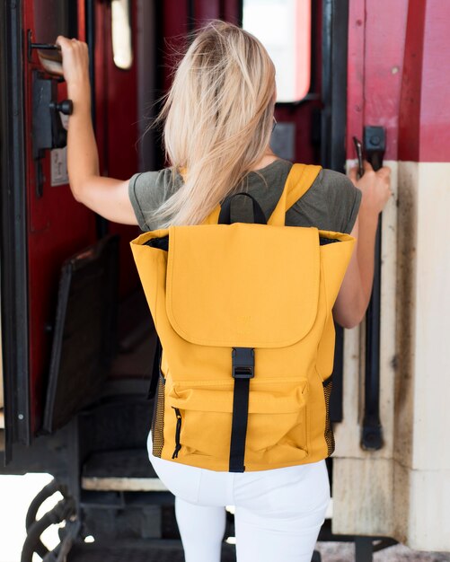 Donna a metà tiro che sale sul treno