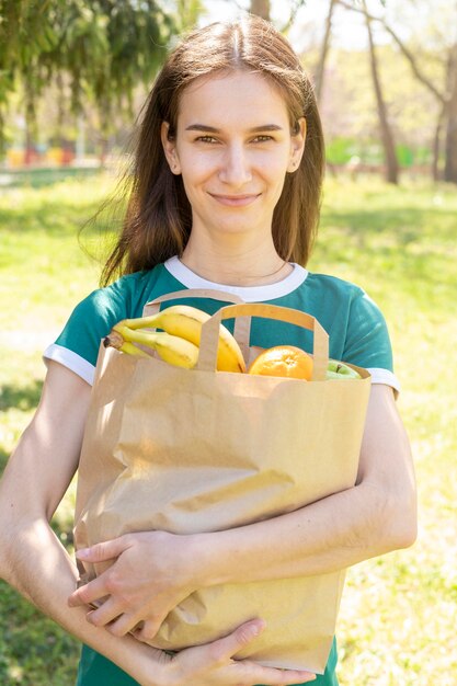 Mid shot woman holding paper bag