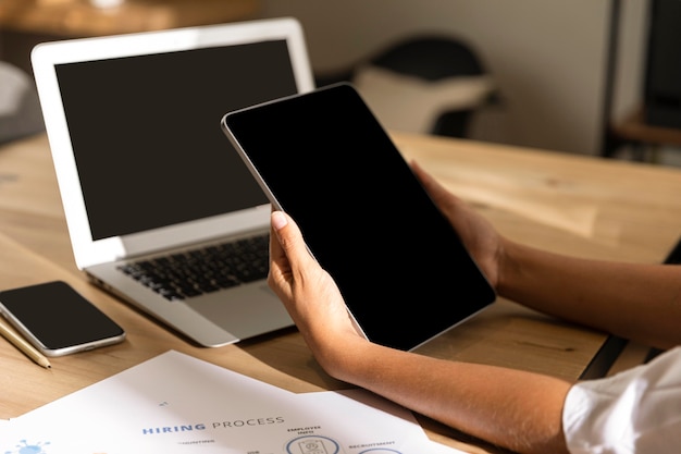 Free photo mid shot woman at table looking at tablet