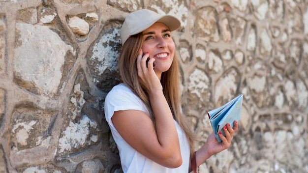 Mid shot woman talking on phone near wall