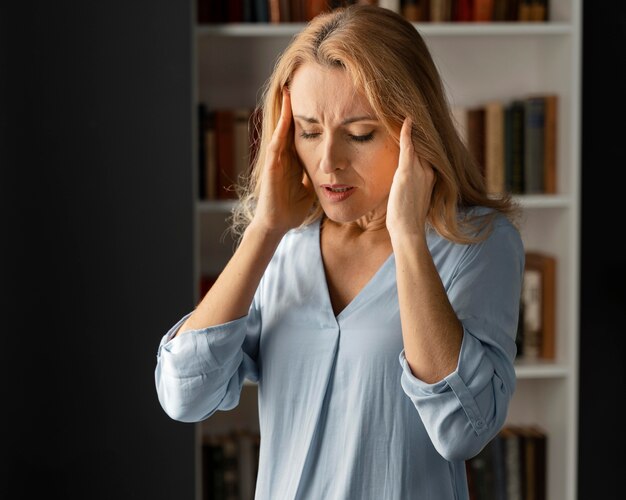 Mid shot woman therapist holding hands on head