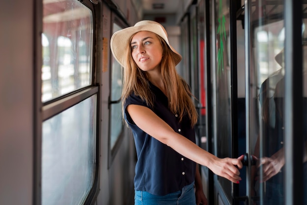 Mid shot woman wearing hat in train