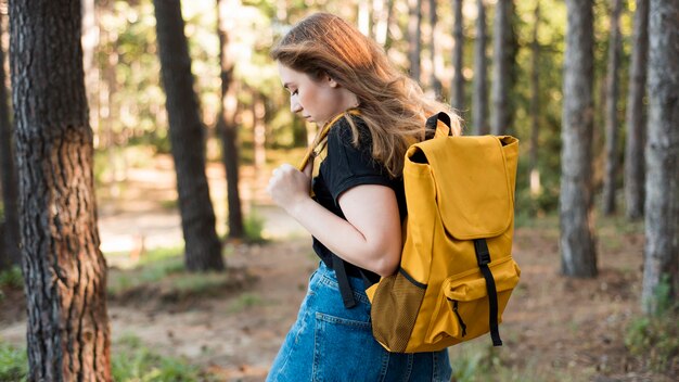 Mid shot woman with backpack in forest