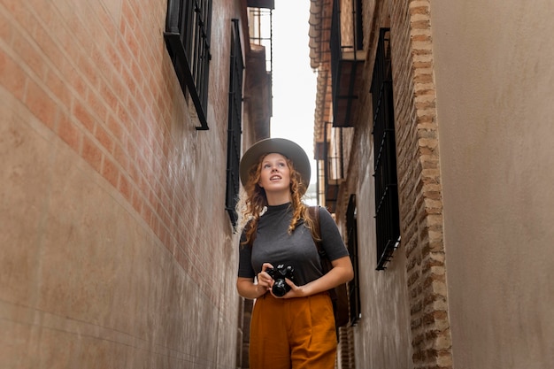 Mid shot woman with hat and camera