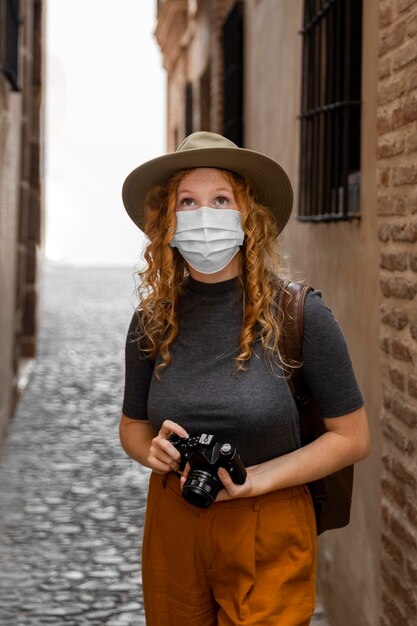 mid shot woman with mask and camera