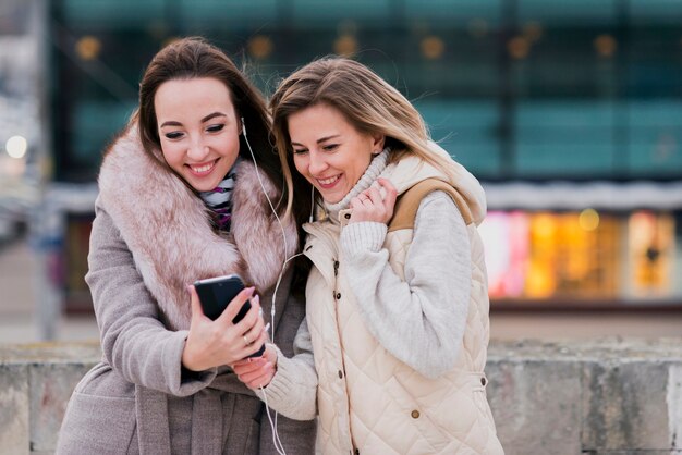 Mid shot women with earphones on roof