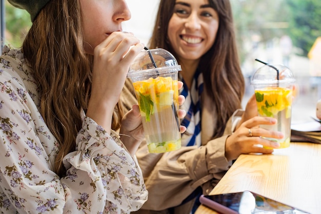 Donne a metà tiro con bevande fresche nella caffetteria