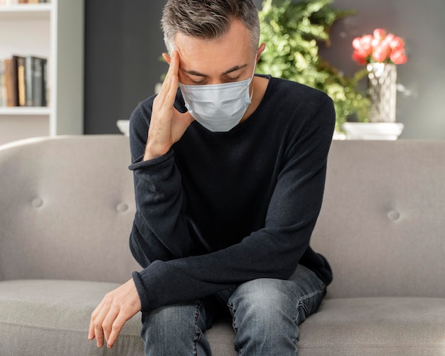 Mid shot worried man with mask in therapy office