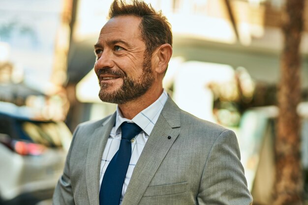 Middle age businessman smiling happy standing at the city