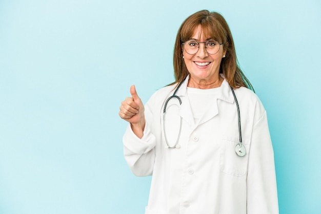 Middle age doctor woman isolated on pink background smiling and raising thumb up