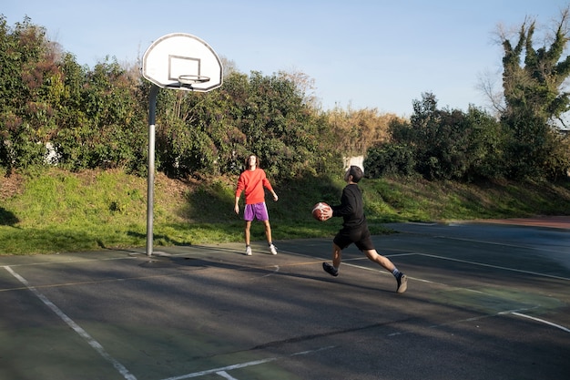 Middle age friends having fun together playing basketball