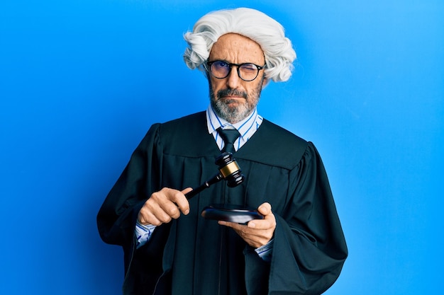 Free photo middle age hispanic man using gavel skeptic and nervous frowning upset because of problem negative person