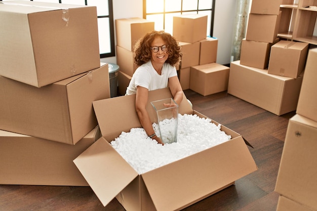 Free photo middle age hispanic woman smiling confident moving at new home