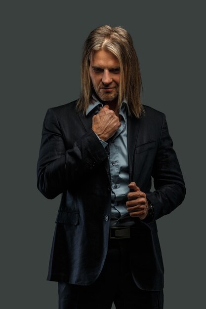 Middle age male in a suit possing in studio. Isolated on grey background.