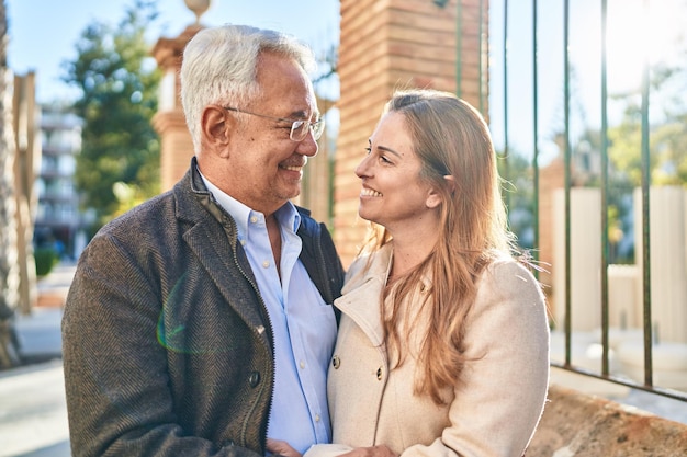 通りに立っている中年の男性と女性のカップルが抱き合っている