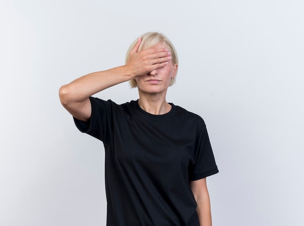 Middle-aged blonde slavic woman covering eyes with hand isolated on white background with copy space